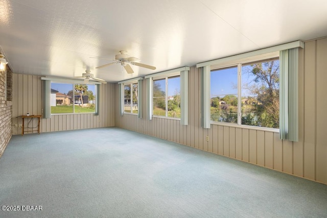 unfurnished sunroom featuring a healthy amount of sunlight and ceiling fan