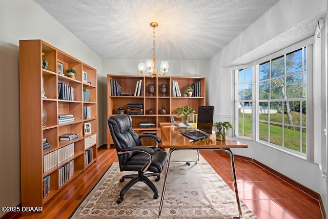 home office featuring a notable chandelier, a textured ceiling, baseboards, and wood finished floors