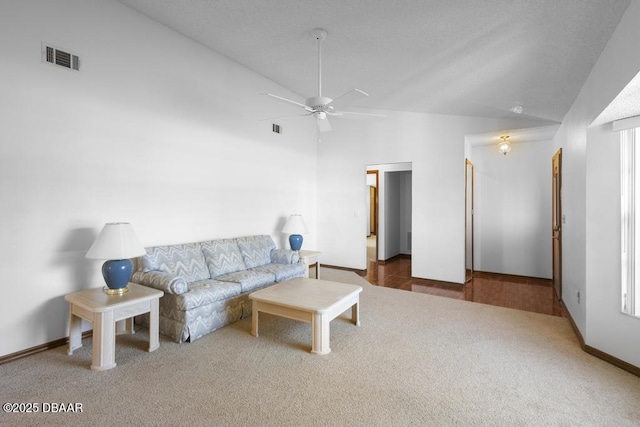 living room with ceiling fan, carpet floors, high vaulted ceiling, and visible vents