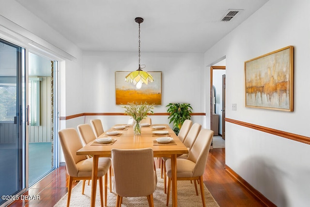 dining area featuring wood finished floors, visible vents, and baseboards