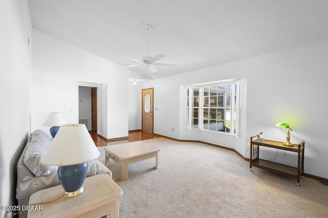 living room with vaulted ceiling, carpet floors, ceiling fan, and baseboards