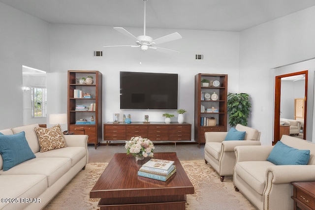 living area with light carpet, ceiling fan, a high ceiling, and visible vents