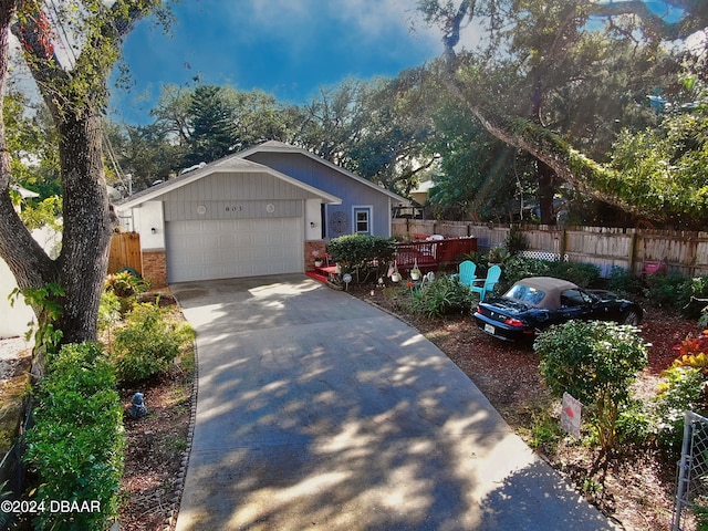 view of front facade featuring a wooden deck and a garage