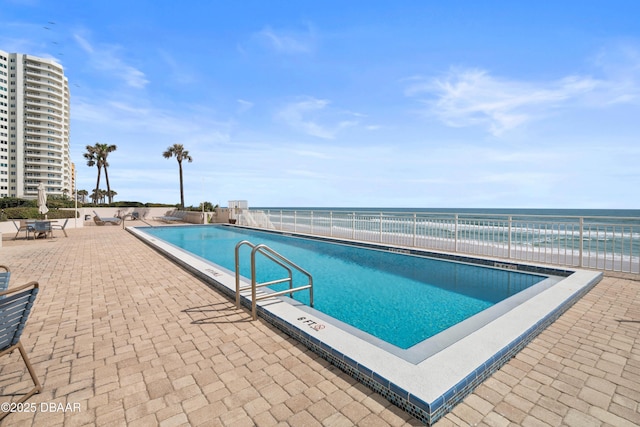 community pool with fence and a patio area