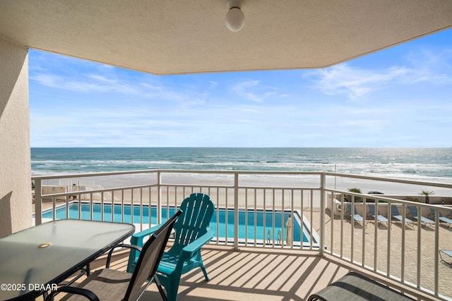 balcony featuring a beach view and a water view