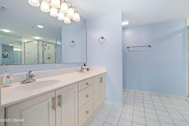 full bathroom featuring visible vents, a stall shower, tile patterned flooring, and a sink