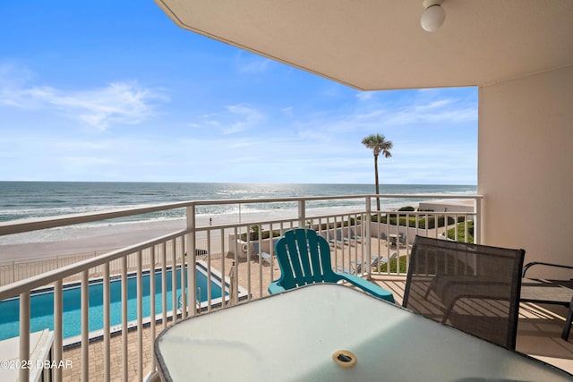 balcony featuring a beach view and a water view