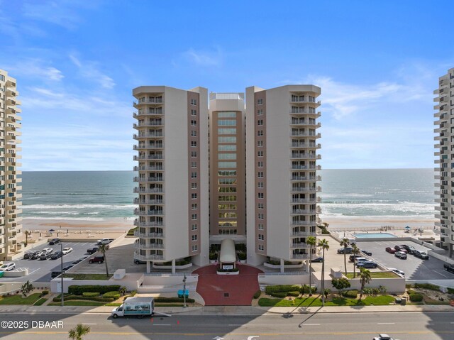 view of property with a view of the beach and a water view