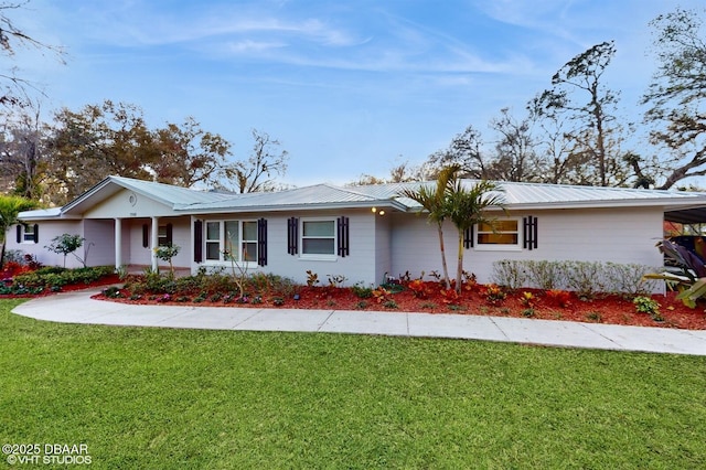 ranch-style house featuring metal roof and a front lawn