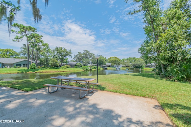 view of home's community with a water view and a yard