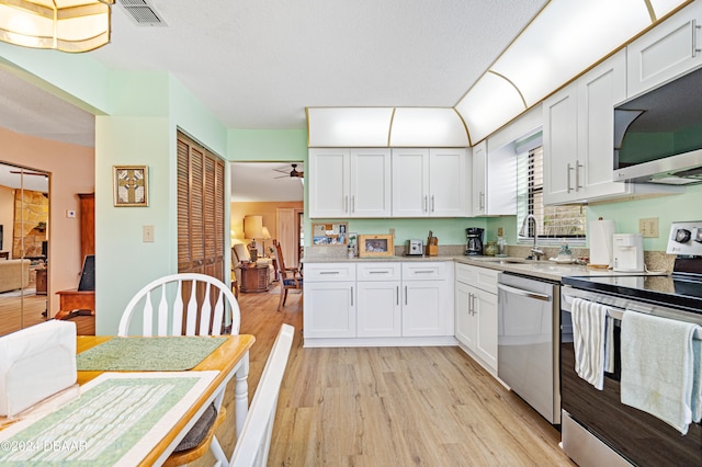 kitchen with white cabinetry, sink, ceiling fan, appliances with stainless steel finishes, and light wood-type flooring