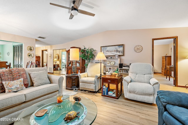 living room featuring ceiling fan, lofted ceiling, and light wood-type flooring