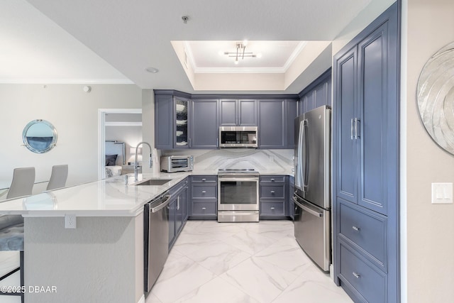 kitchen featuring sink, a breakfast bar area, ornamental molding, appliances with stainless steel finishes, and kitchen peninsula