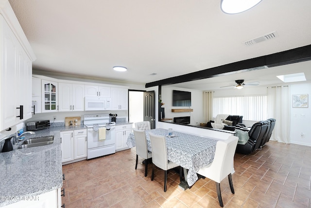 kitchen featuring sink, white appliances, white cabinetry, and beamed ceiling