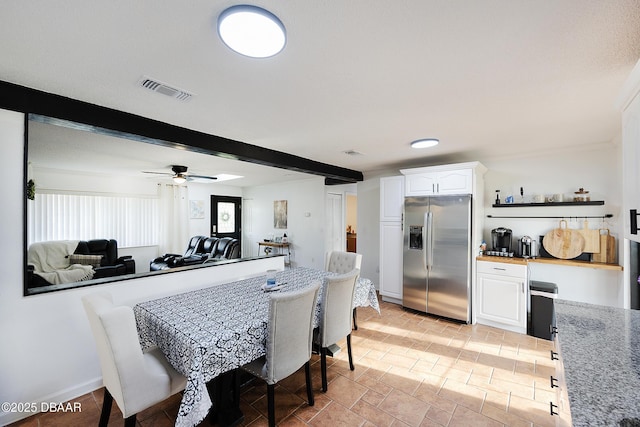 dining room featuring ceiling fan and beamed ceiling