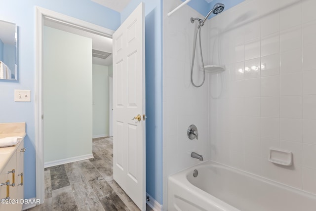 bathroom with vanity, tiled shower / bath combo, and hardwood / wood-style flooring