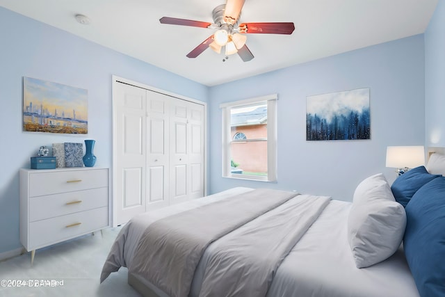 bedroom with ceiling fan, light colored carpet, and a closet