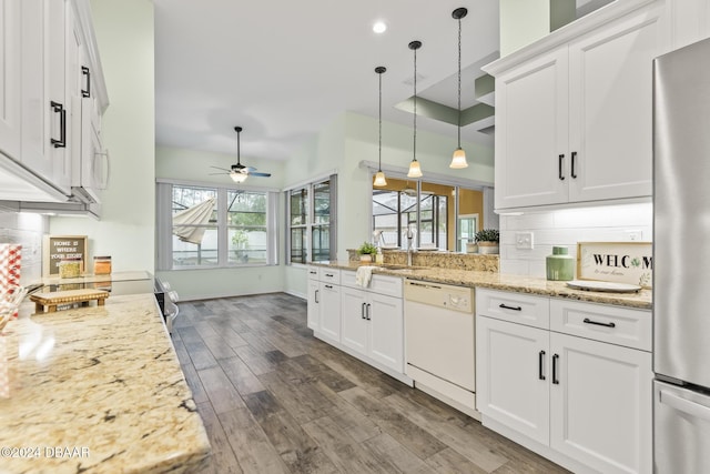 kitchen with light stone countertops, ceiling fan, dishwasher, white cabinetry, and stainless steel refrigerator