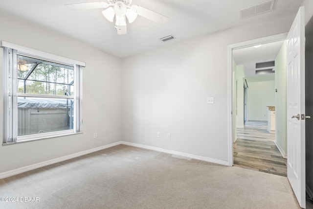 carpeted spare room featuring ceiling fan