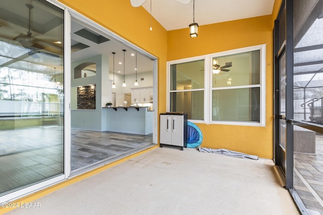 unfurnished sunroom with ceiling fan