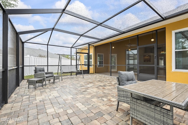 view of patio / terrace featuring glass enclosure and ceiling fan