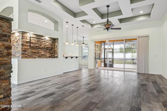 unfurnished living room with ceiling fan and a towering ceiling