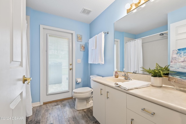 bathroom featuring hardwood / wood-style floors, vanity, toilet, and a wealth of natural light