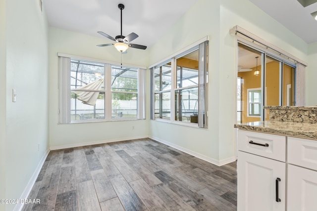 unfurnished sunroom featuring ceiling fan