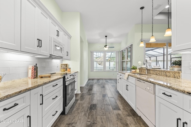 kitchen featuring pendant lighting, white appliances, backsplash, ceiling fan, and white cabinetry