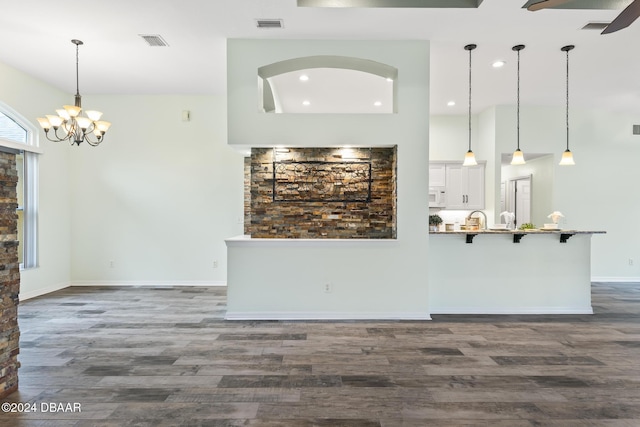 interior space featuring ceiling fan with notable chandelier and dark hardwood / wood-style floors