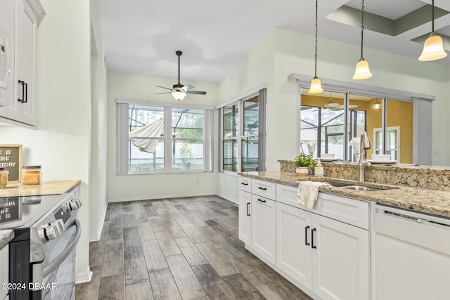 kitchen with electric range, dishwasher, light stone countertops, sink, and white cabinets