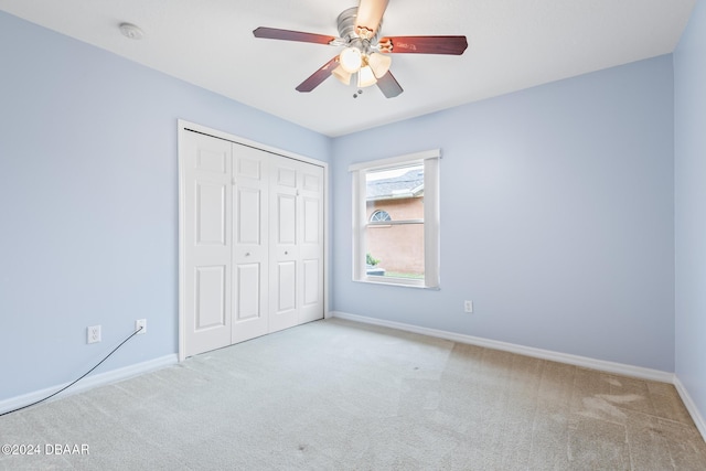 unfurnished bedroom with light carpet, a closet, and ceiling fan