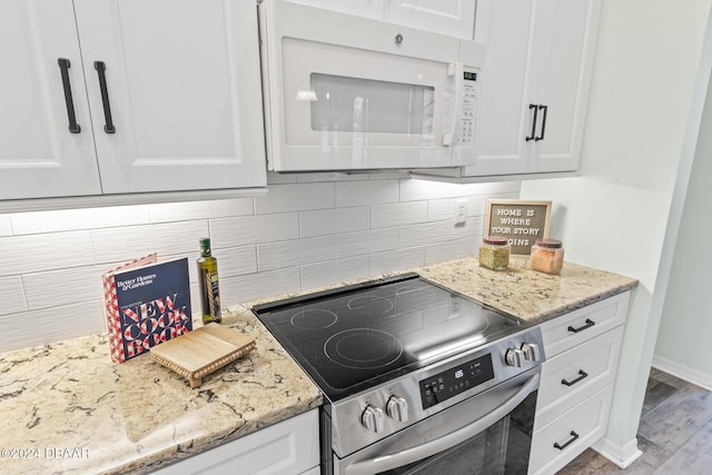 kitchen featuring stainless steel range with electric stovetop, decorative backsplash, and white cabinets