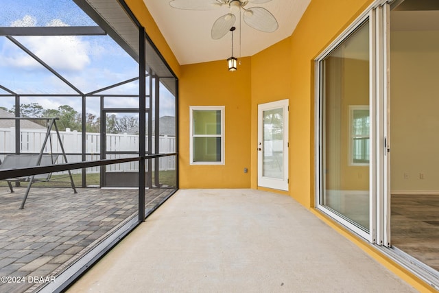 unfurnished sunroom with ceiling fan, a healthy amount of sunlight, and lofted ceiling