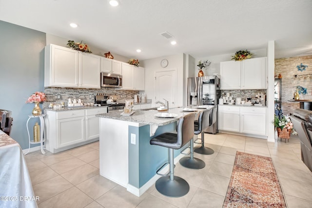 316 Nowell Loop, Deland, FL 32724 - kitchen featuring stainless steel appliances, decorative backsplash, a kitchen breakfast bar, white cabinets, and recessed lighting