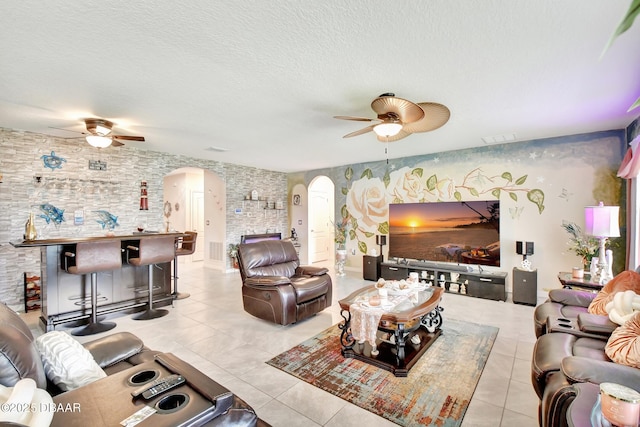 316 Nowell Loop, Deland, FL 32724 - living room featuring a ceiling fan, arched walkways, light tile patterned floors, and a textured ceiling