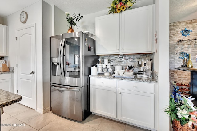316 Nowell Loop, Deland, FL 32724 - kitchen featuring stainless steel refrigerator with ice dispenser, tasteful backsplash, white cabinets, light tile patterned floors, and a textured ceiling