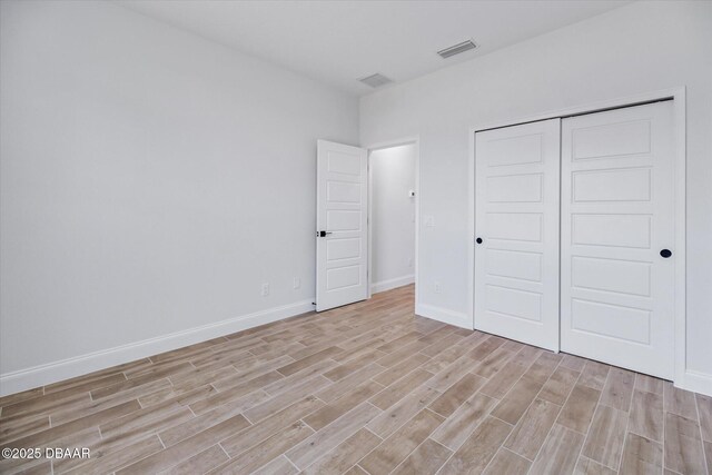45 Fenhill Ln, Palm Coast, FL 32137 - unfurnished bedroom with light wood-style floors, baseboards, and a closet