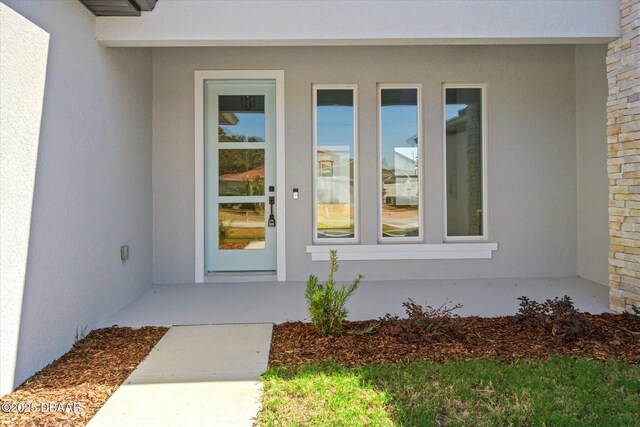 45 Fenhill Ln, Palm Coast, FL 32137 - doorway to property featuring stucco siding