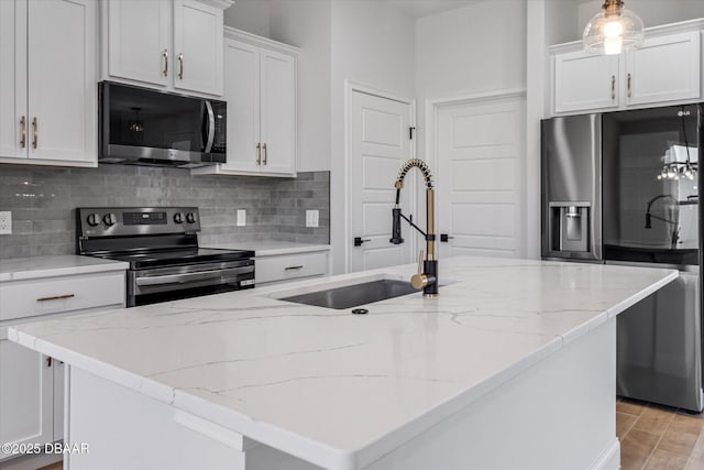 45 Fenhill Ln, Palm Coast, FL 32137 - kitchen with appliances with stainless steel finishes, a sink, backsplash, white cabinetry, and light stone counters
