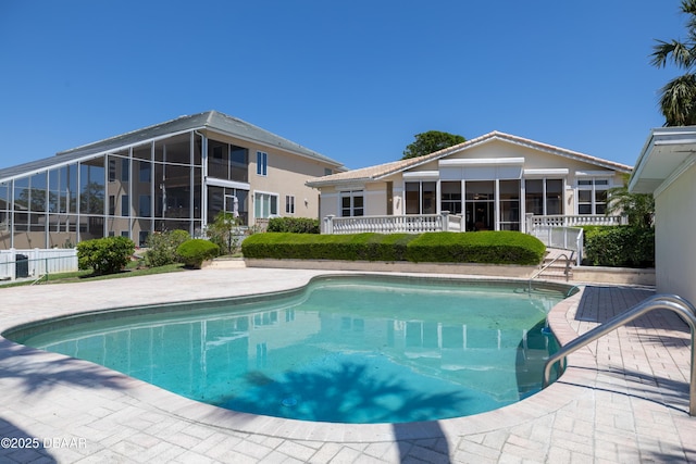 pool featuring fence and a sunroom