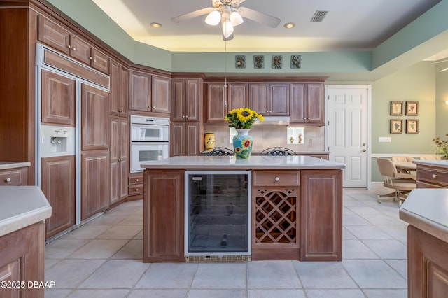 kitchen with beverage cooler, light countertops, and double oven