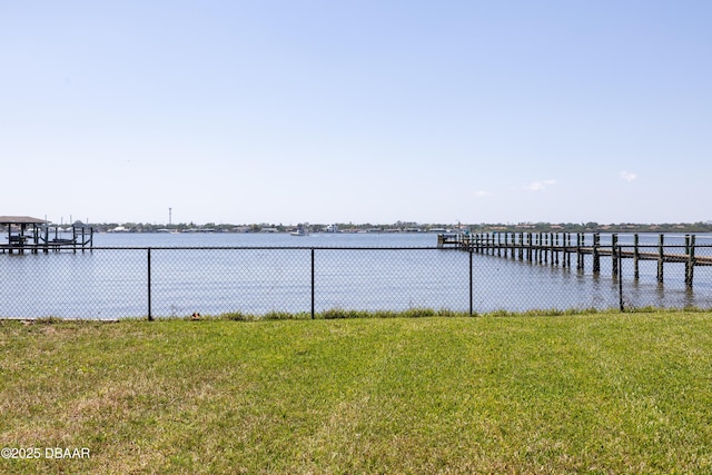 view of dock with a yard and a water view