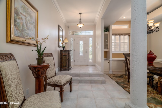 entrance foyer featuring ornate columns, ornamental molding, tile patterned flooring, and baseboards
