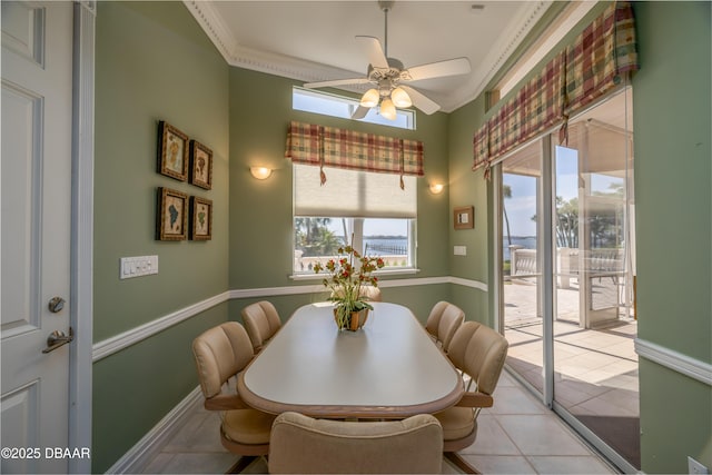 dining room featuring light tile patterned flooring, ceiling fan, ornamental molding, and baseboards