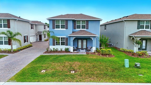 3049 Meleto Blvd, New Smyrna Beach, FL 32168 - traditional home with decorative driveway, stucco siding, french doors, and a front yard