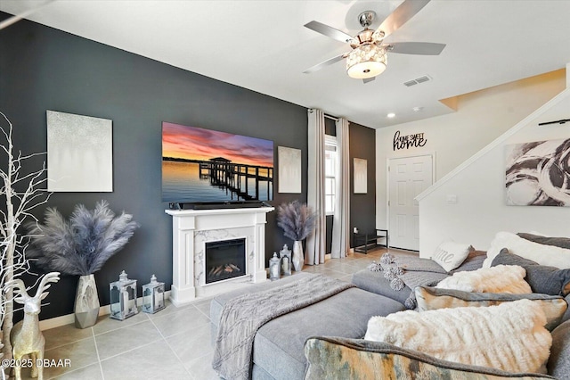 3049 Meleto Blvd, New Smyrna Beach, FL 32168 - tiled living room featuring ceiling fan, baseboards, an accent wall, a high end fireplace, and stairway
