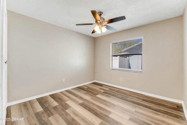 empty room featuring wood finished floors, baseboards, and ceiling fan