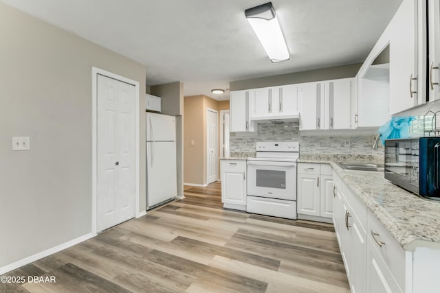 kitchen featuring backsplash, under cabinet range hood, white cabinets, white appliances, and a sink