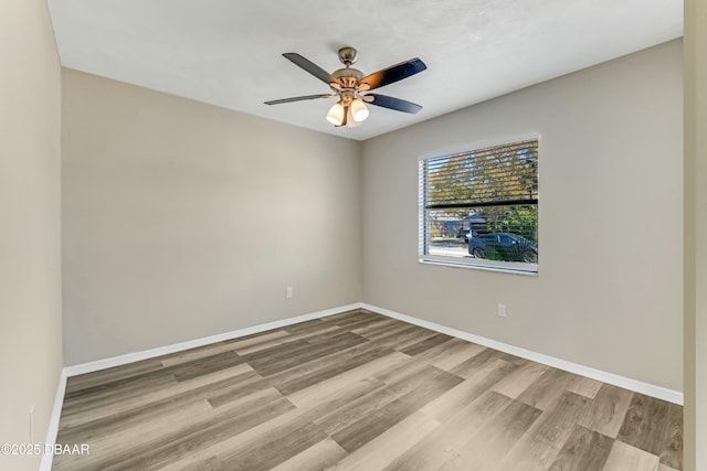 empty room featuring ceiling fan, baseboards, and wood finished floors